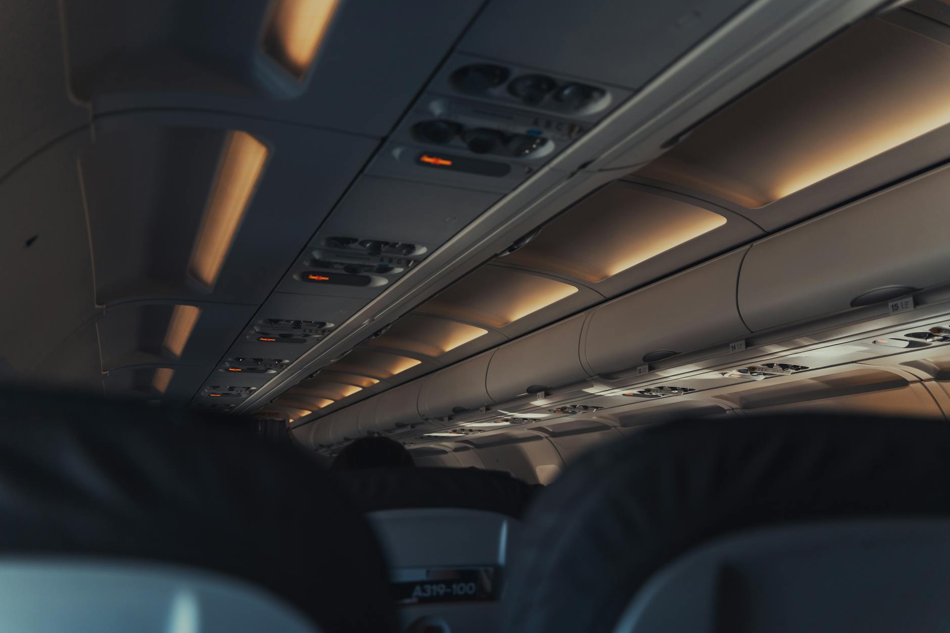 Modern aircraft cabin interior with passenger seats and overhead controls
