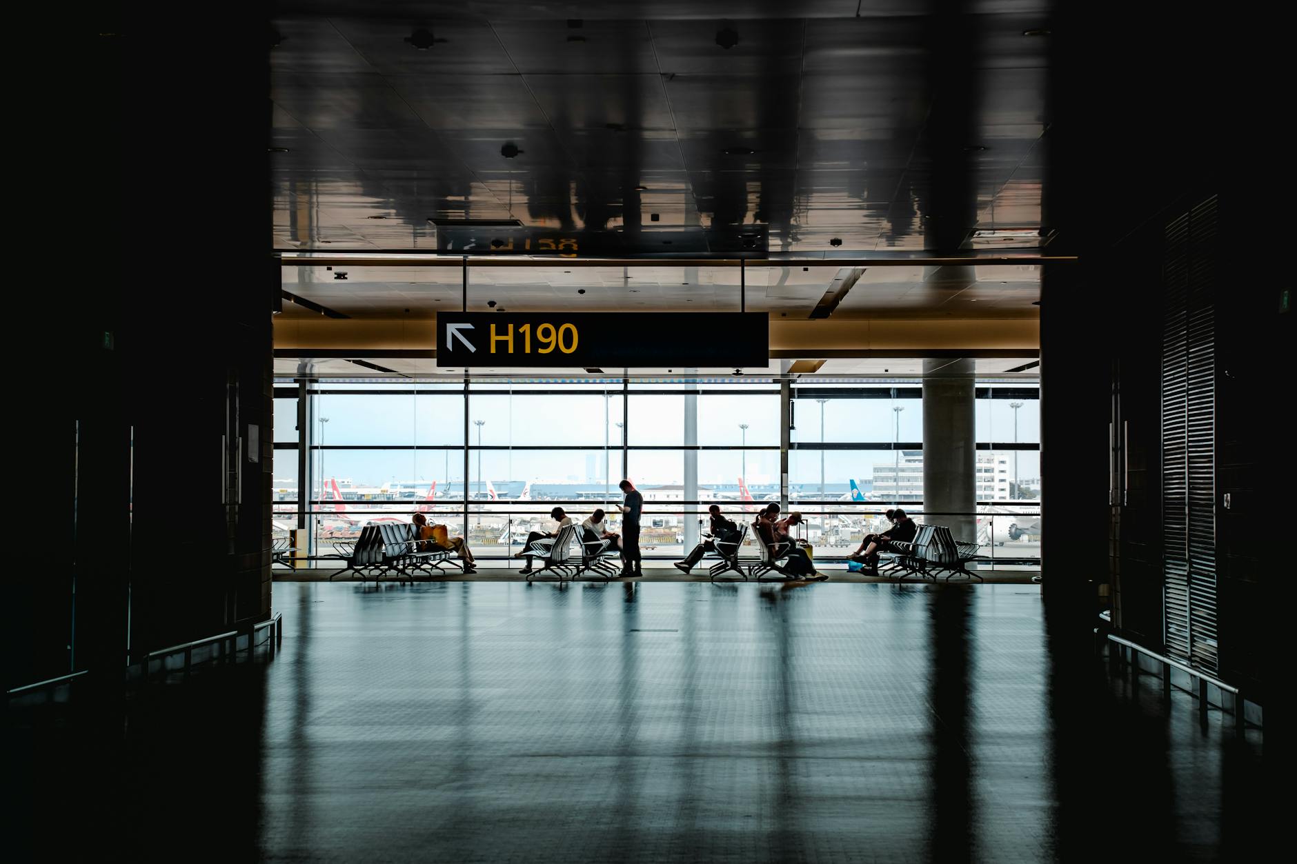 Modern airport gate area with seating and departure screens