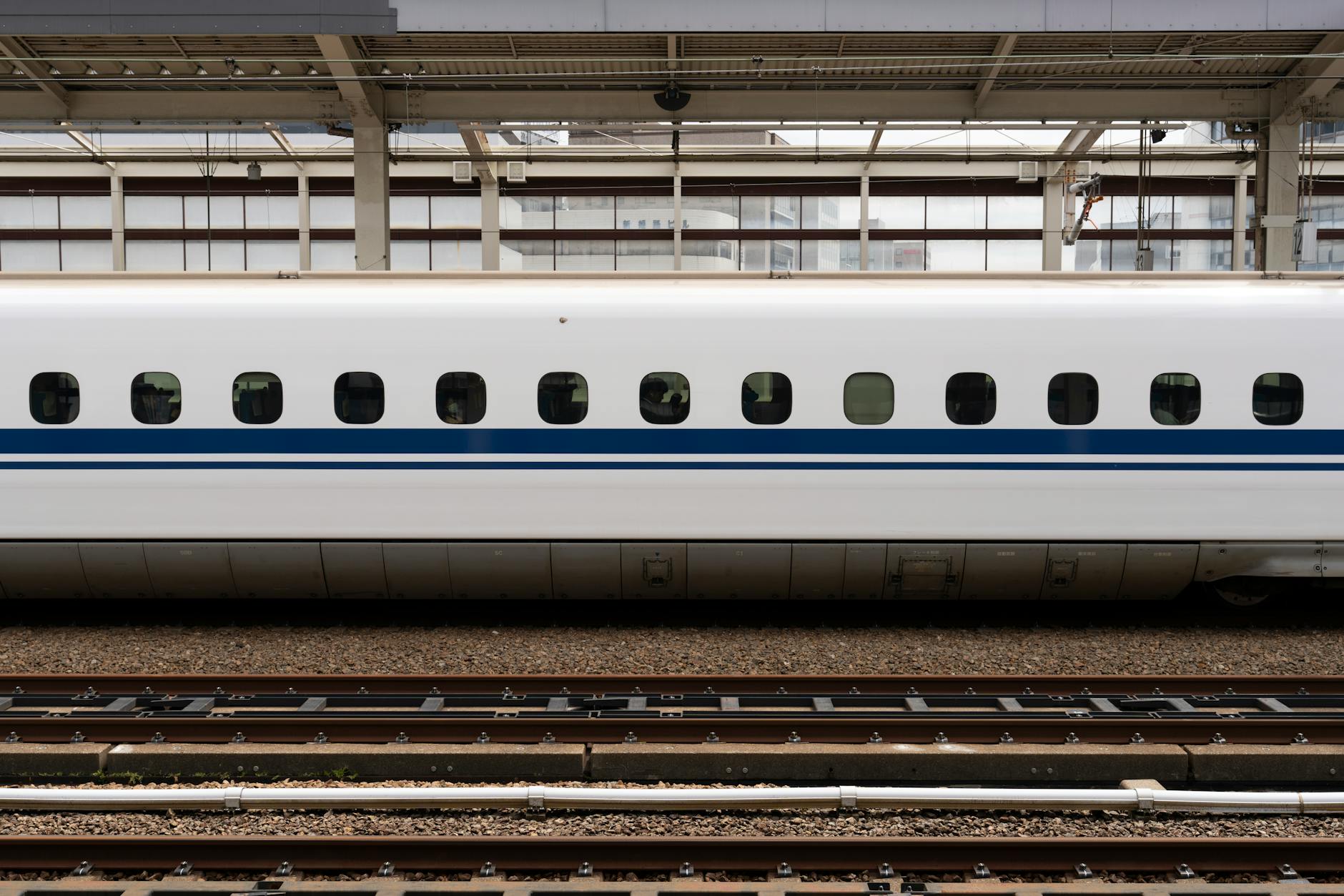 Modern Japanese bullet train traveling through snowy mountain landscape