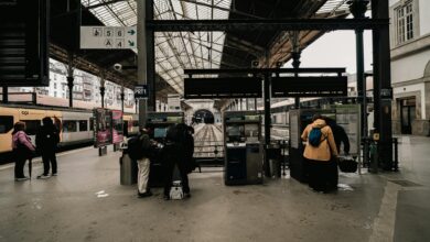 European train station platform with modern high-speed trains and travelers with luggage