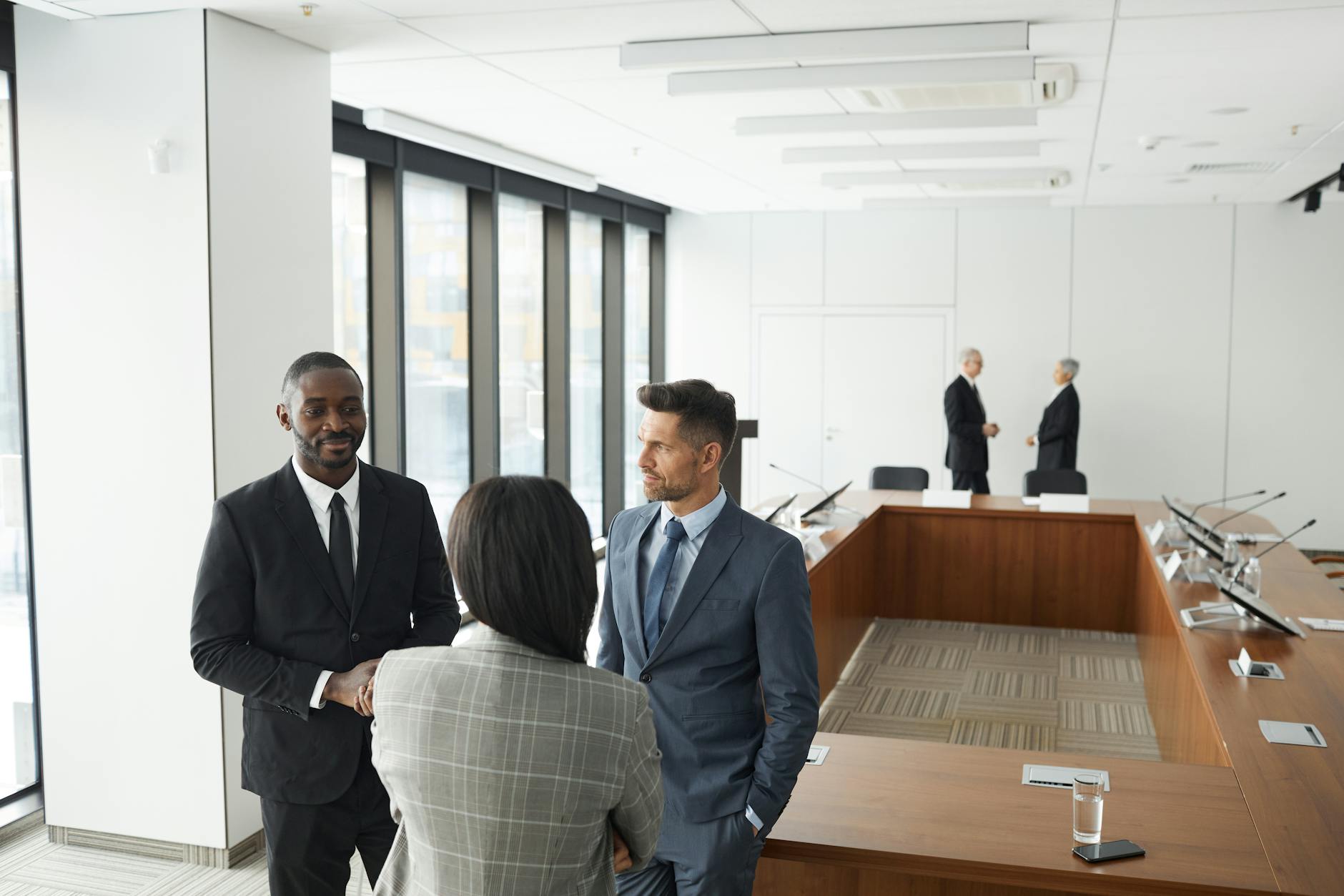 Professional business meeting with executives around conference table in modern office