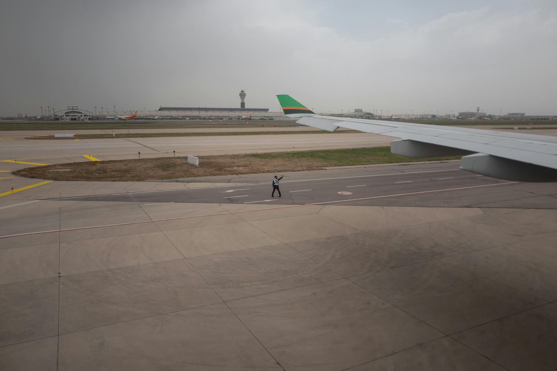 Travelers moving through airport security checkpoint with metal detectors and screening equipment