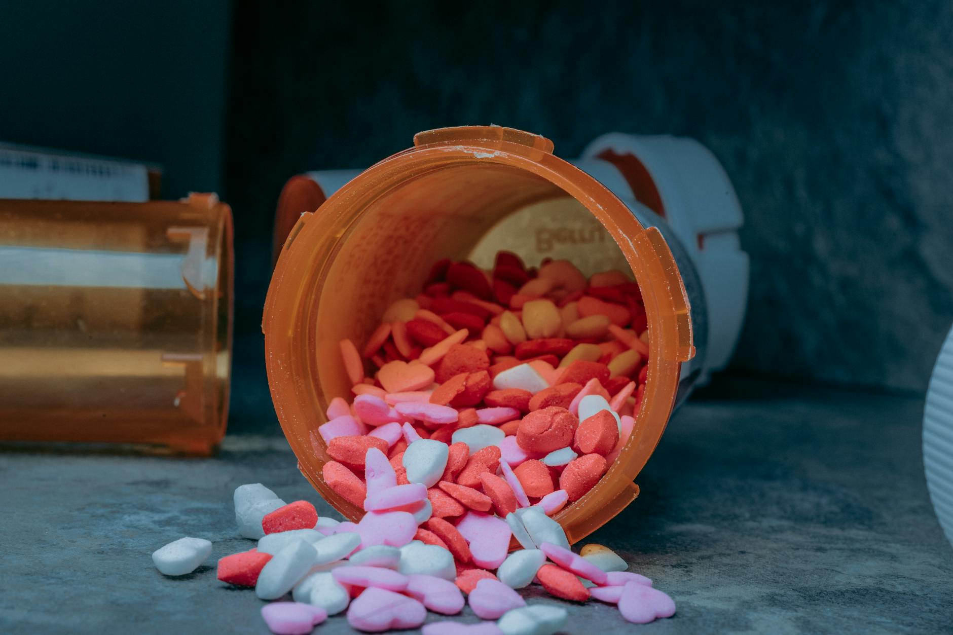 Multiple prescription medication bottles with pharmacy labels arranged on a table
