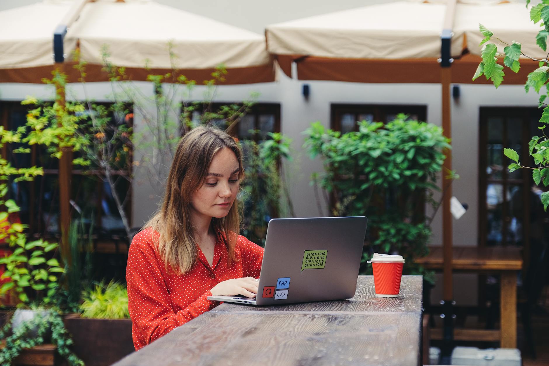 Digital nomad working on laptop in European cafe setting