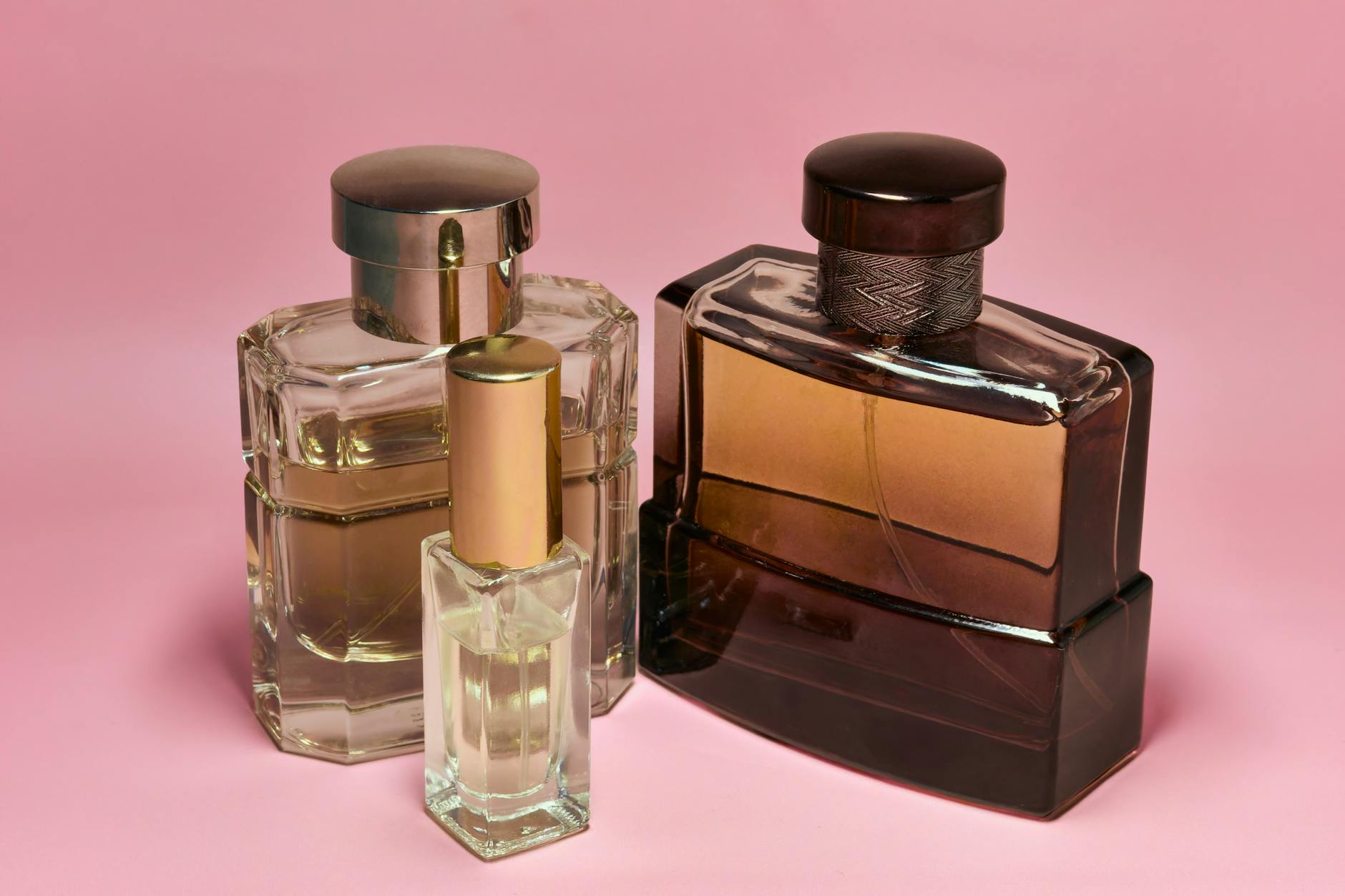 Small glass perfume bottles arranged on wooden surface for fragrance blending workshop