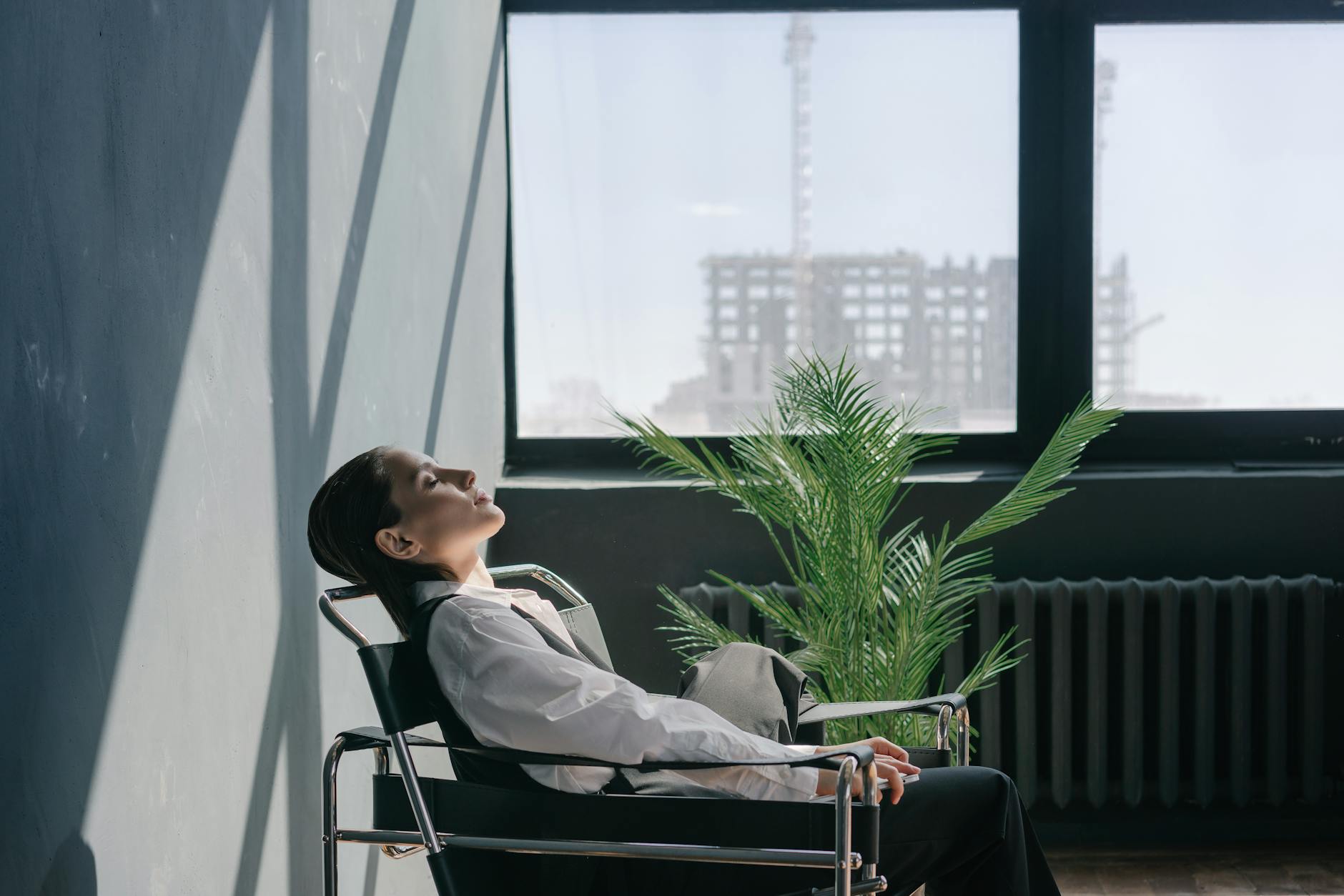 Professional in business attire practicing mindfulness in modern office setting