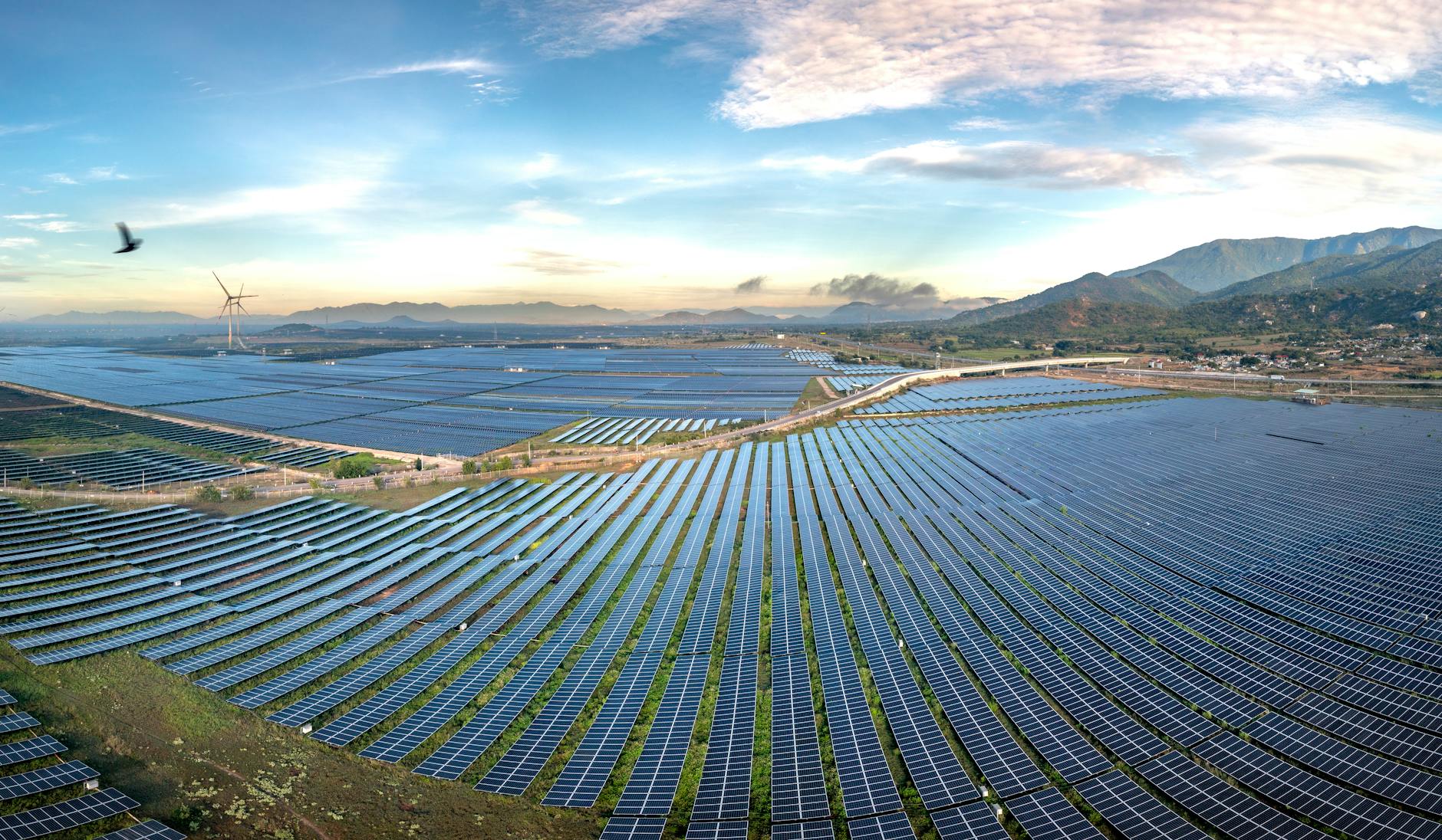 Solar panel installation on mountain building with snow-capped peaks in background  