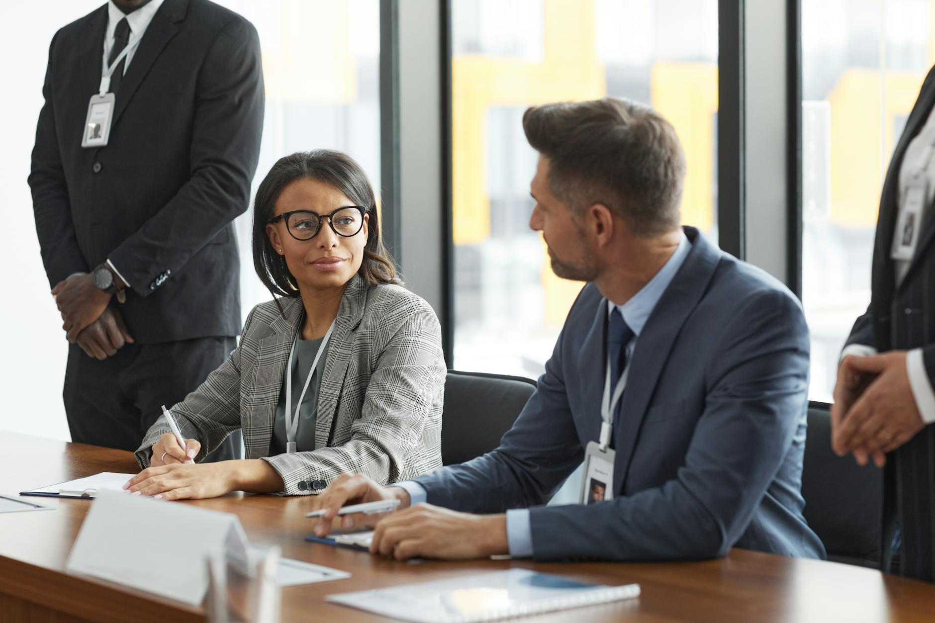 Executive assistant coordinating with business professionals in a conference room environment