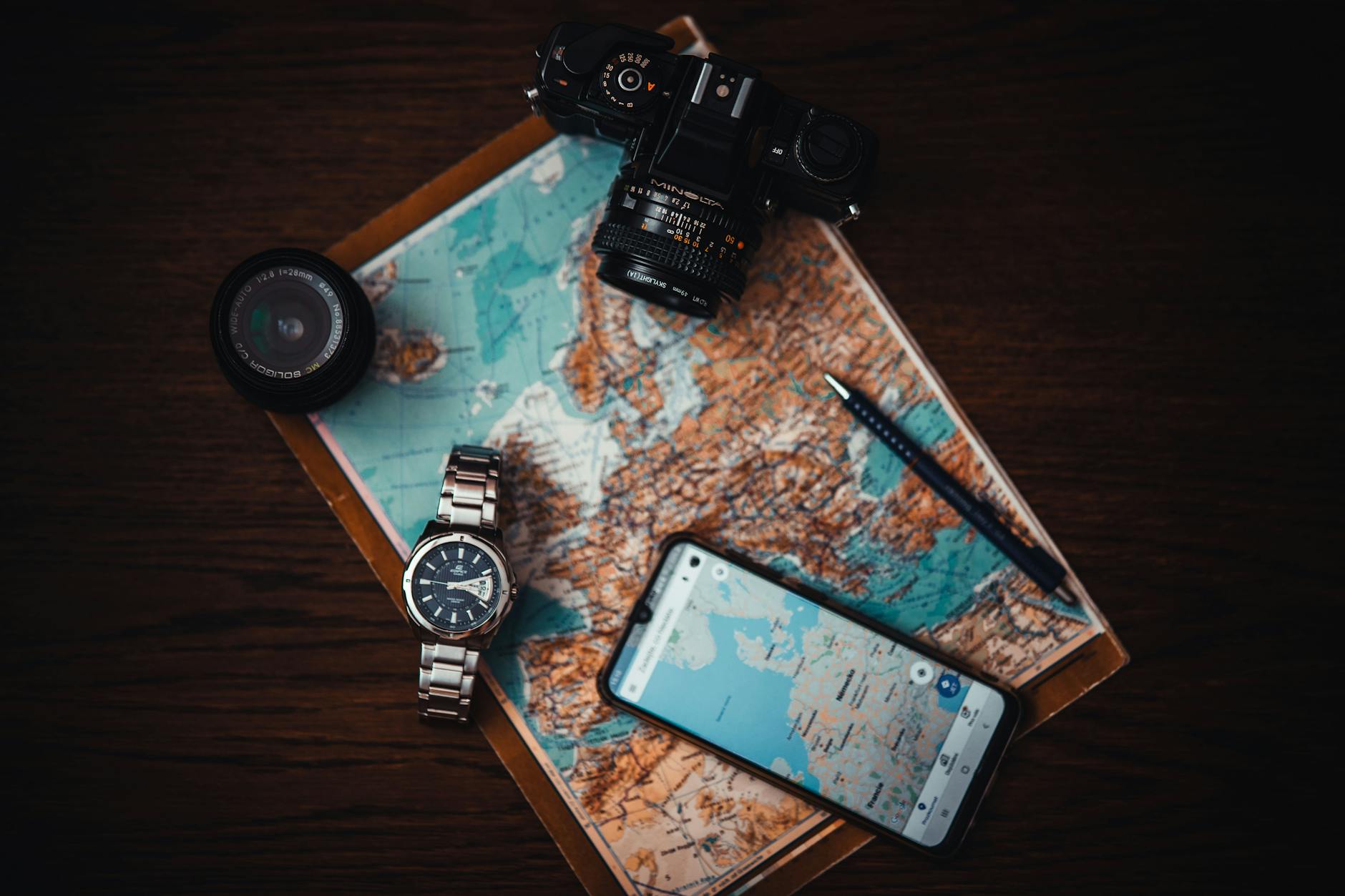 Collection of travel electronics including phone charger, adapter, and portable battery on white background