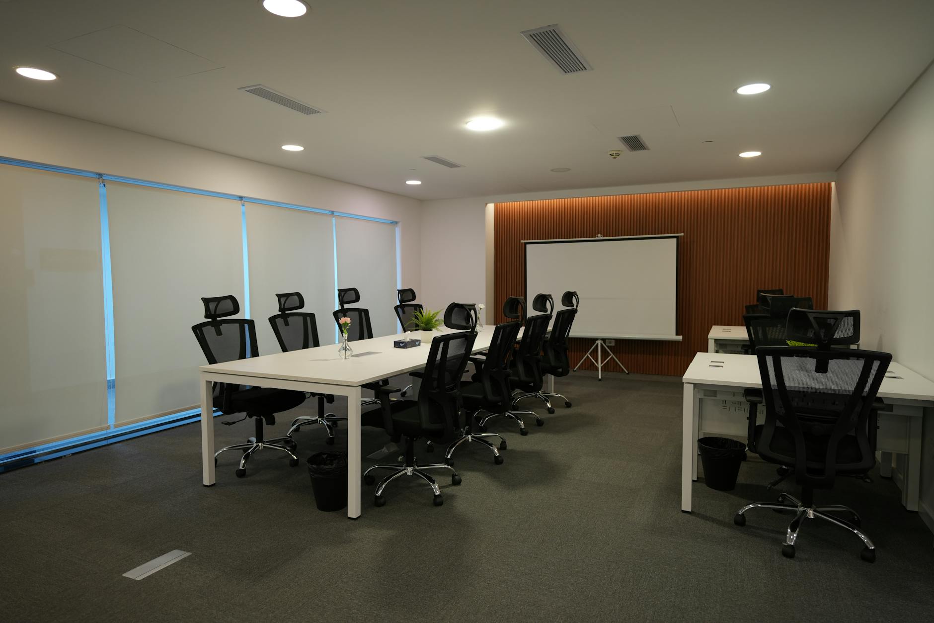Modern co-working space with multiple people working at shared tables and computers
