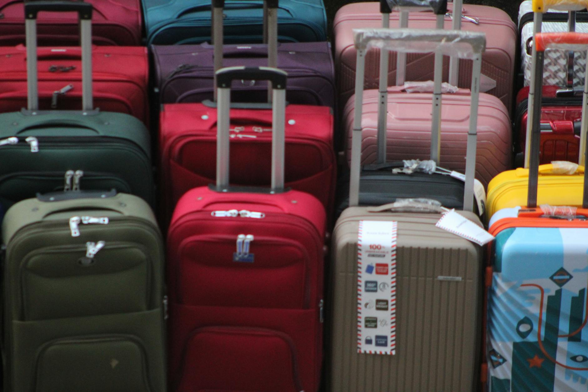 Airport baggage claim carousel with multiple suitcases and travelers waiting