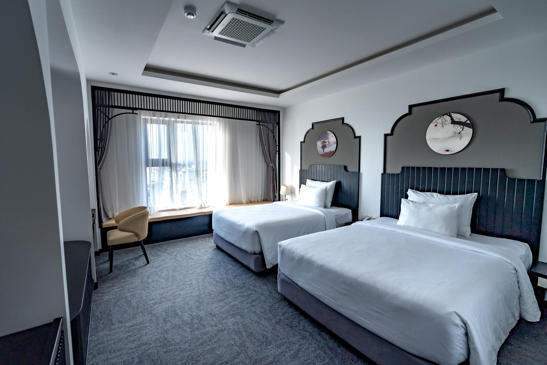 Modern hotel room with large windows and natural light streaming in