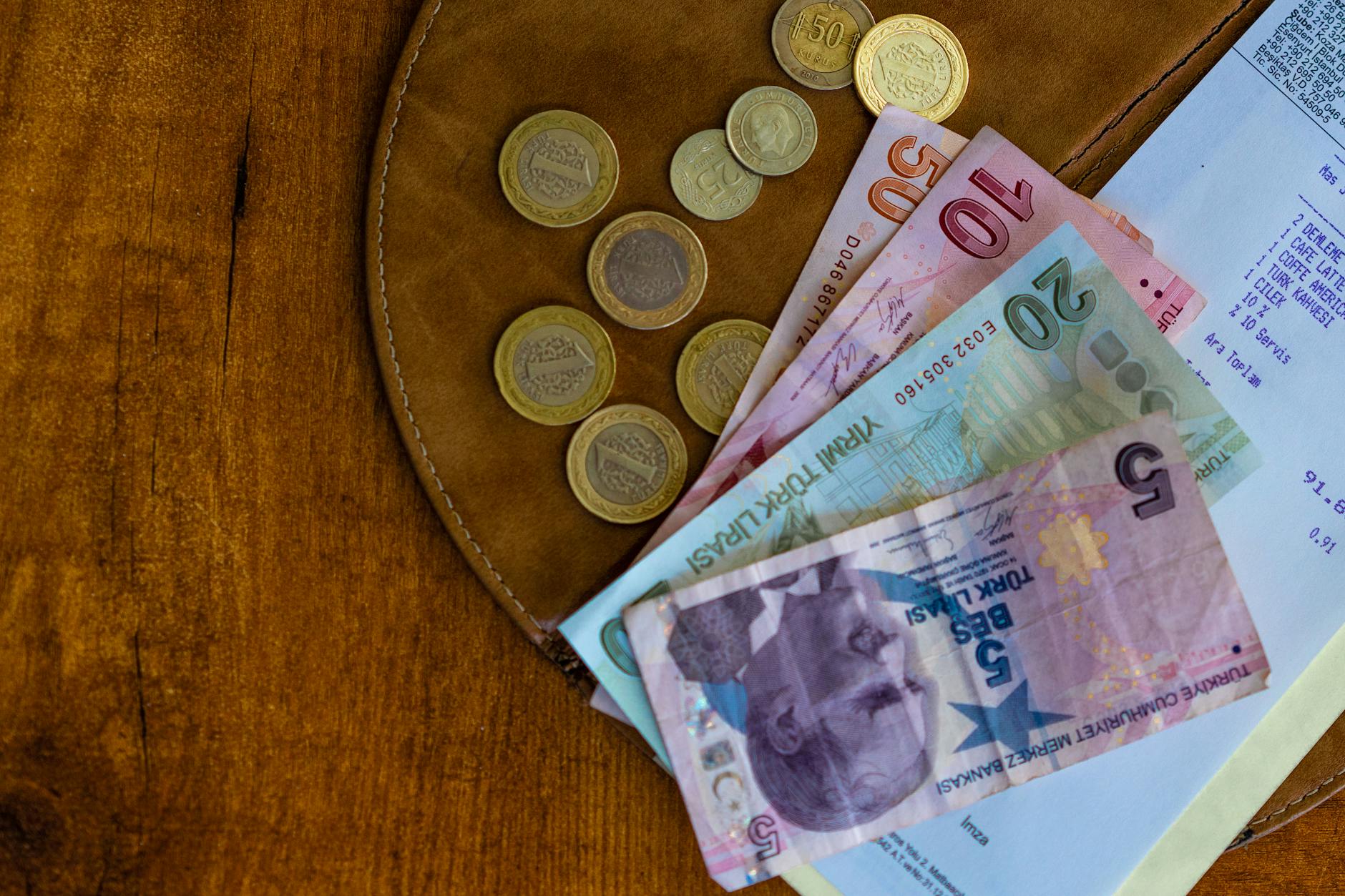 Wallet with international currency and travel cards on world map