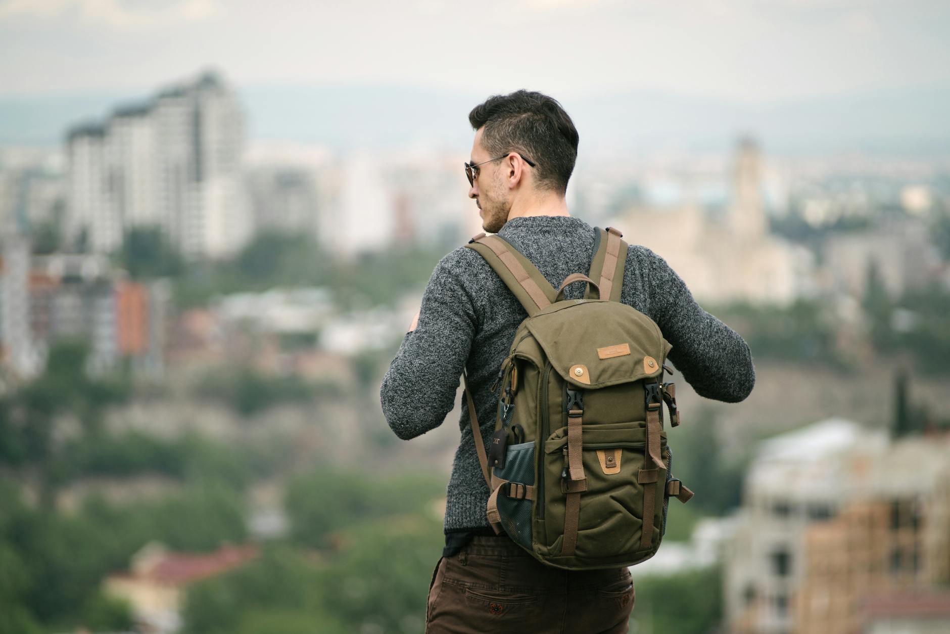 Traveler with backpack exploring European city street, representing hostel travel culture