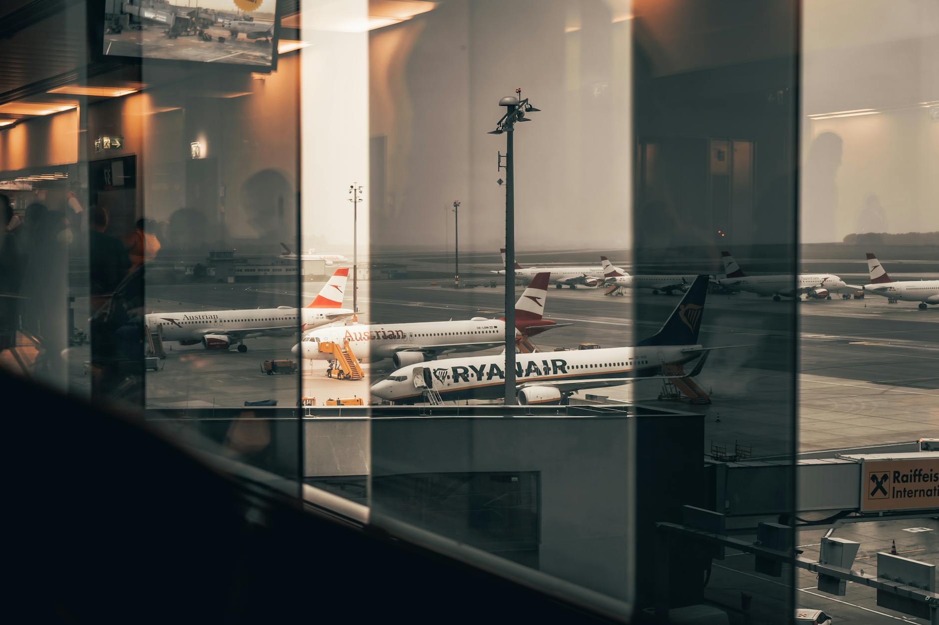Modern airport boarding gate with passengers and electronic displays