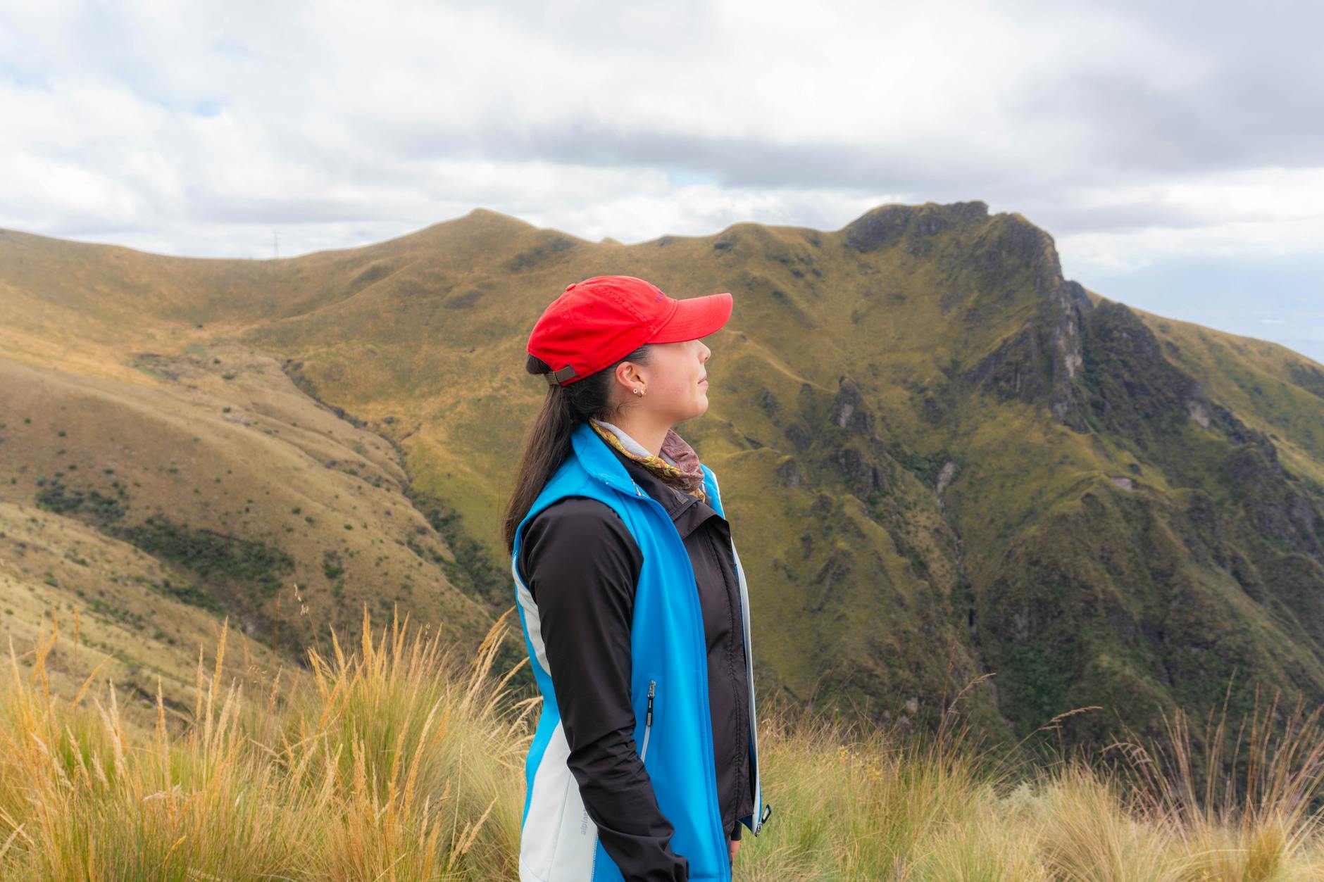 Hiker on a mountain trail in the Andes with sweeping views of glacial valleys below