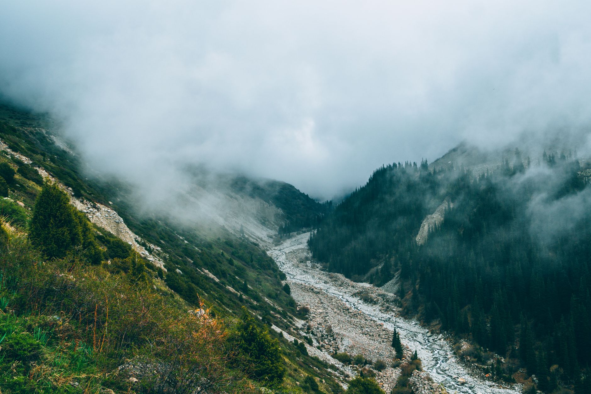 A narrow valley flanked by high mountain peaks in a remote Central Asian landscape