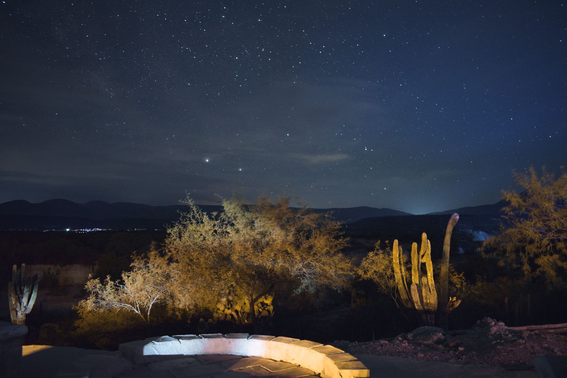 Brilliant night sky filled with stars above a flat, open desert landscape