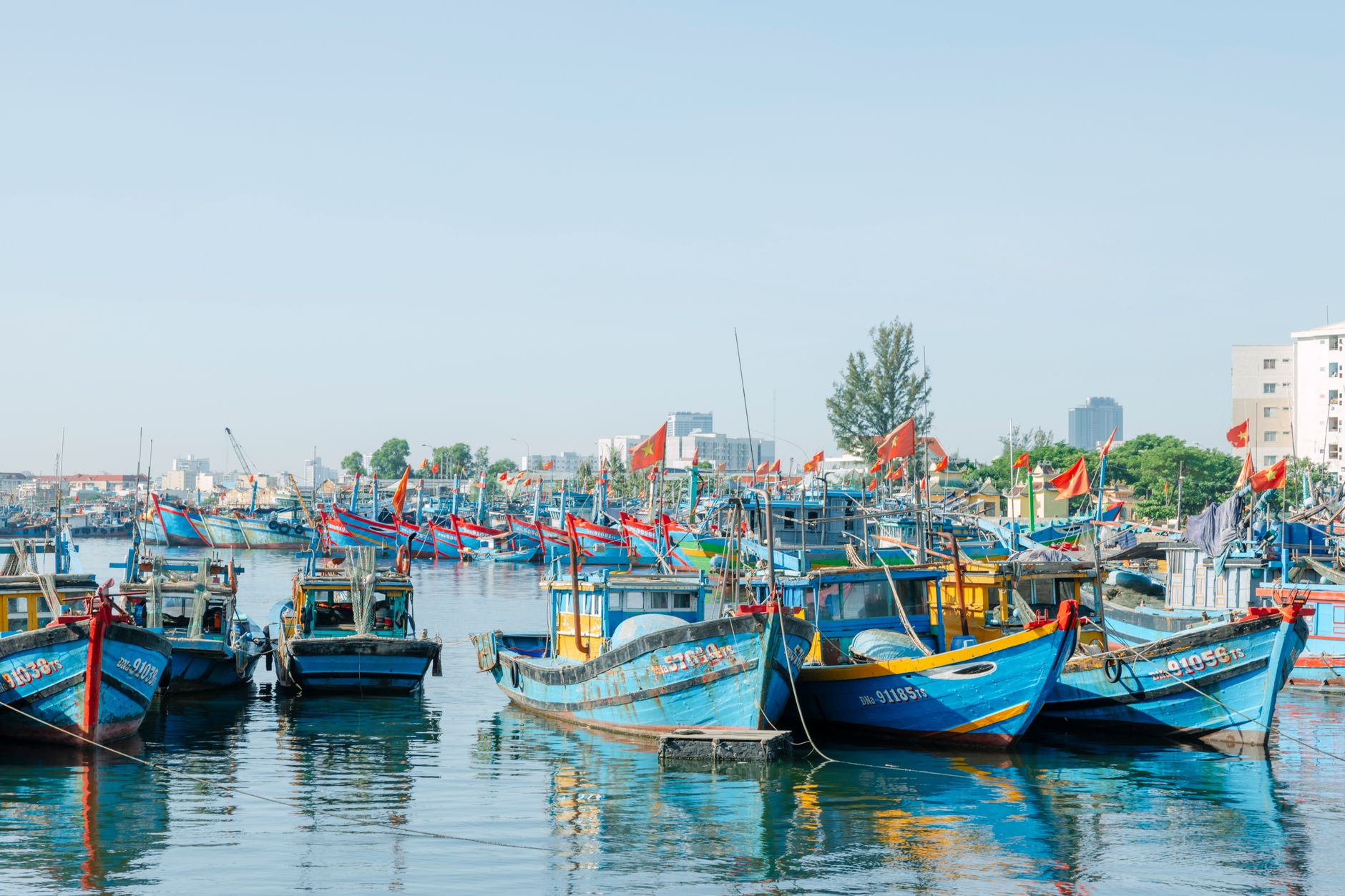 Colorful traditional fishing boats moored in a small harbor at dusk