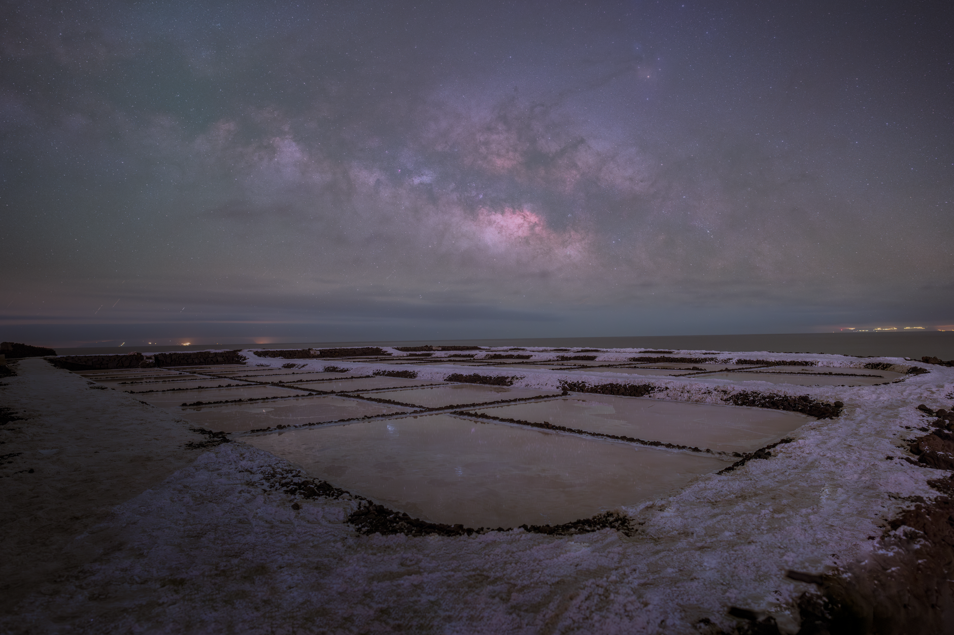 Wide view of the Uyuni Salt Flats reflecting a star-filled night sky in Bolivia