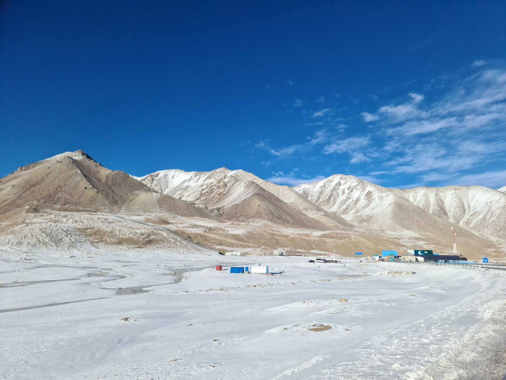 Mountain road through a Central Asian pass leading into a fertile valley