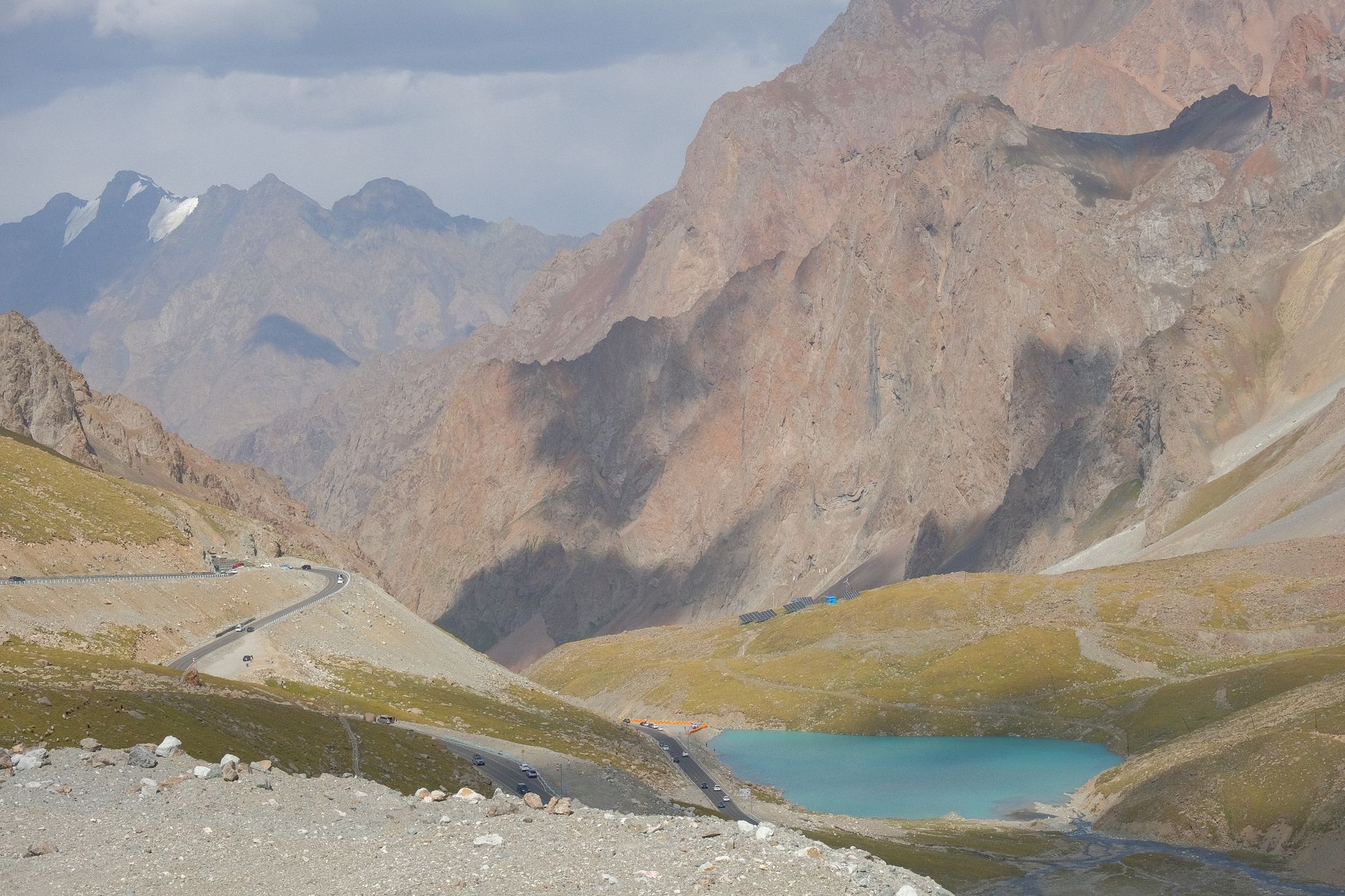 Brilliant turquoise glacial lake reflecting surrounding rocky mountain peaks under a clear blue sky