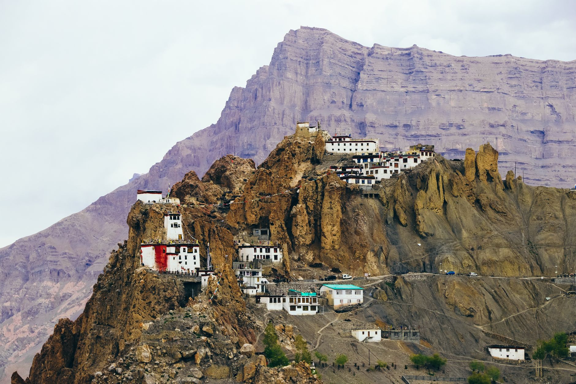 Ancient Buddhist monastery carved into a sandstone cliff face in a remote Himalayan desert region