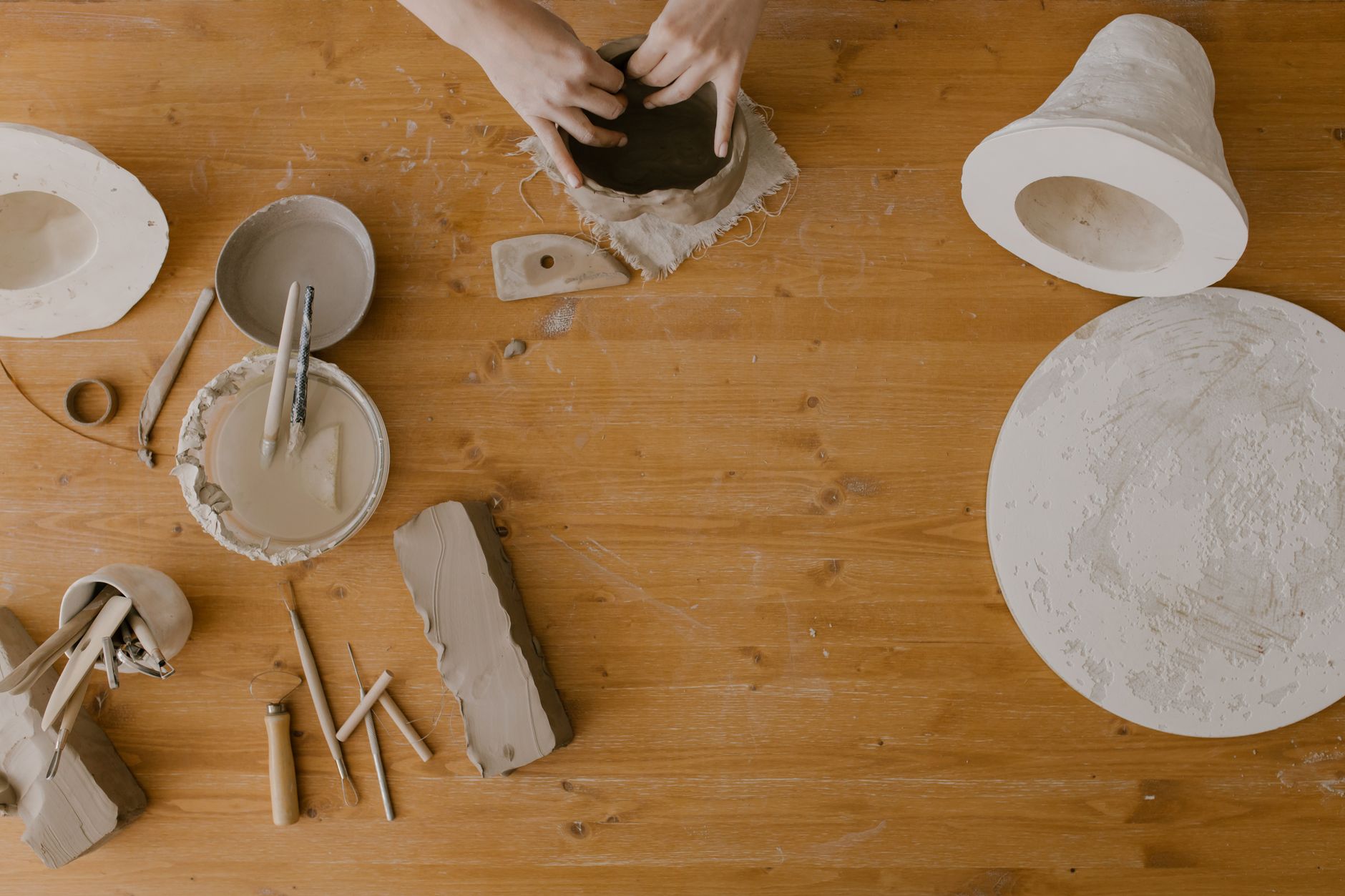 Handmade ceramic plates with blue-green glaze drying in a traditional pottery workshop