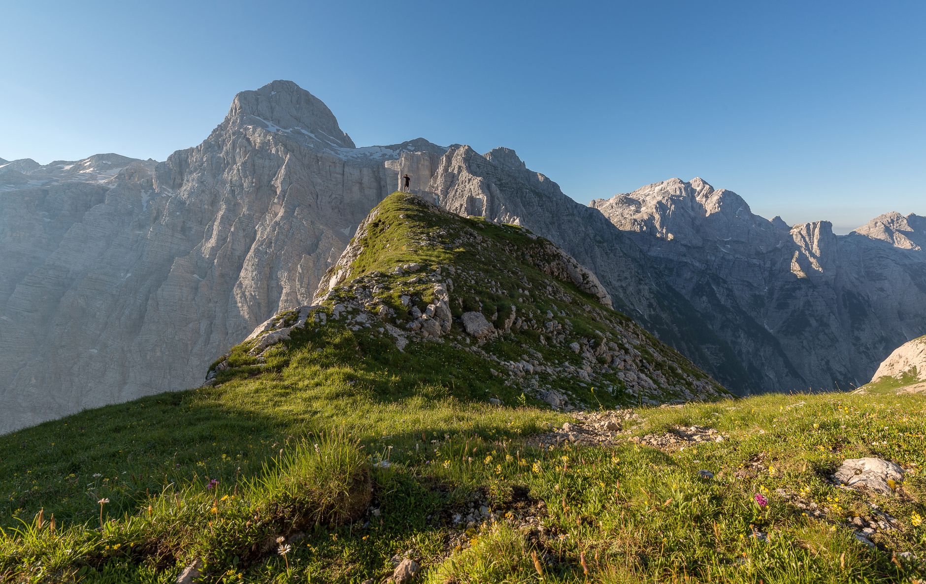 Hikers on a mountain trail with dramatic alpine peaks in the background
