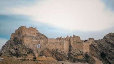 Ancient stone fortress ruins on a rocky mountain ridge against a clear sky