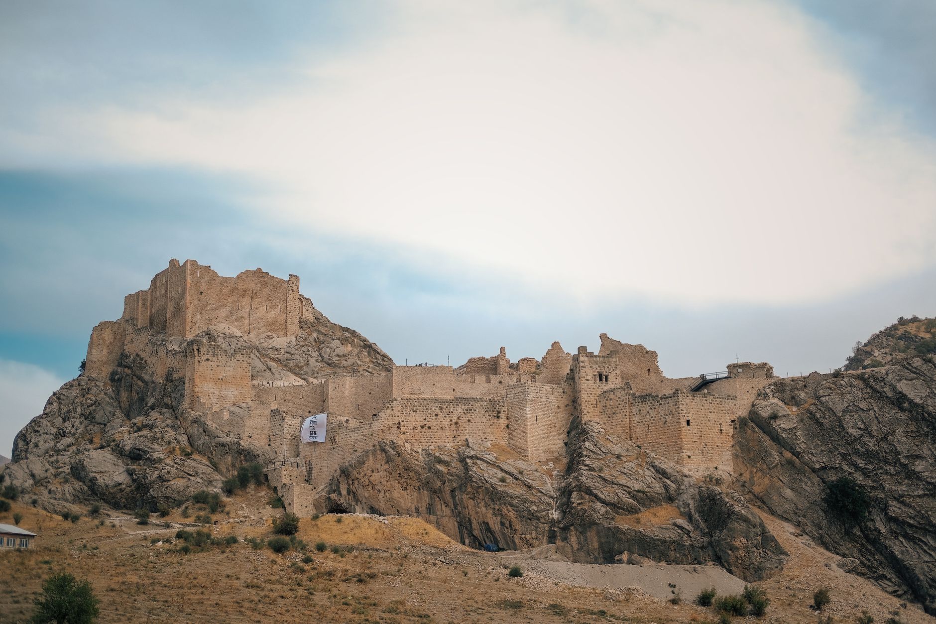 Ancient stone fortress ruins on a rocky mountain ridge against a clear sky