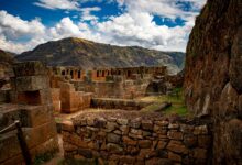 Ancient Inca stone terraces and ruins set against a mountainous jungle backdrop in Peru