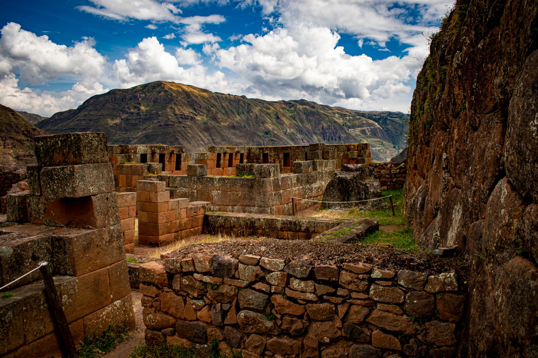 Ancient Inca stone terraces and ruins set against a mountainous jungle backdrop in Peru