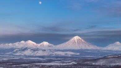 Snow-capped stratovolcano rising above an altiplano landscape at dawn