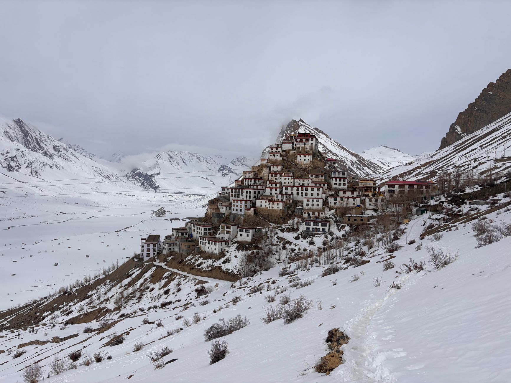 Ancient stone monastery on a hillside in the Himalayas surrounded by prayer flags