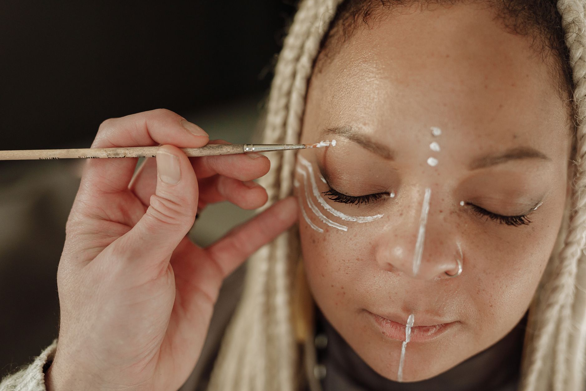 Close-up of intricate traditional body painting patterns in ochre and white chalk